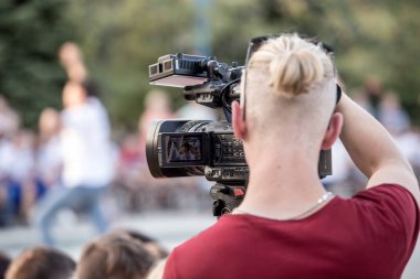 Mariupol, Ukrayna - 24 Eylül 2019: sahne konseptinin arkasında. Profesyonel kamerada çalışan kameraman şehir sokaklarında film çekiyor..