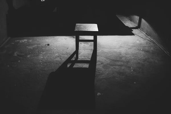 一个凳子在一个空荡荡的黑暗和可怕的房间 — 图库照片