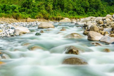 Güzel bir dağ nehir tropikal tepeler ve arka planda bir Kota Belud Sabah Malezya Borneo, Mount Kinabalu ile kayalar arasında akan doğal manzarası.