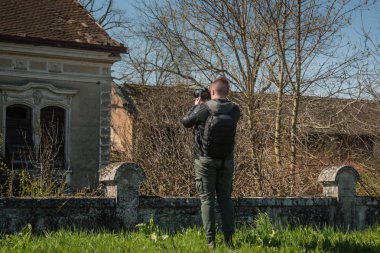 Kamerayla fotoğraf çeken ve geniş bir alanı keşfeden adam.
