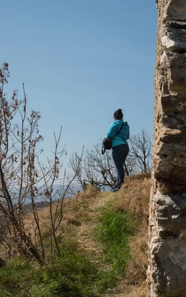 Ormanda yürüyen bir kız, dağda, eski şatonun yanında, mavi elbiseli.