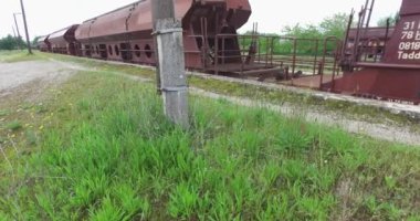 Arka planda mavi gökyüzü ile platforma park yük vagonları.