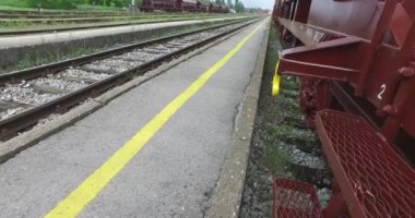 Arka planda mavi gökyüzü platformunda park edilmiş yük vagonları yakın video.