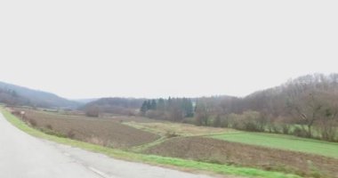 Sonbaharda ya da kışın kırsal bir araziyle çevrili dolambaçlı bir yolda giderken.