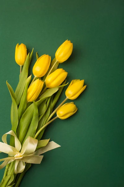 Spring card: yellow tulips on a green background. Top view, lay flat — Stock Photo, Image