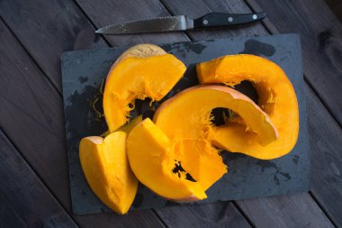 Koyu ahşap bir masada doğranmış kabak.