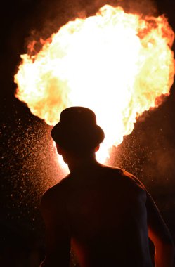 Ateş yiyici bir partiye ateş püskürtüyor.