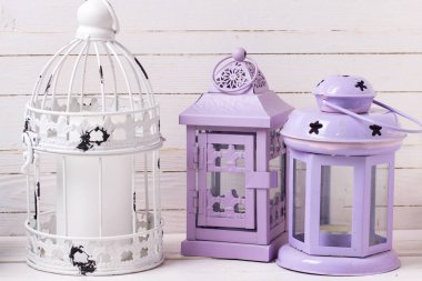 Parlak mor ve beyaz dekoratif fenerler Beyaz ahşap zemin üzerinde. Eski püskü şık dekorasyon. Seçici odak