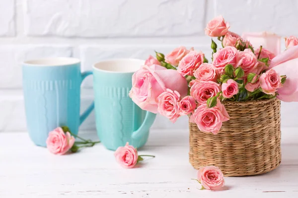Rosarote Rosen Und Bunte Blaue Tassen Vor Weißer Backsteinwand Blumenstillleben — Stockfoto