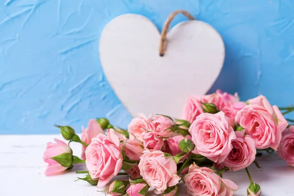 Flores Rosas Rosadas Tiernas Corazón Blanco Sobre Fondo Texturizado Azul —  Fotos de Stock