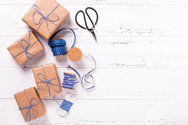 包装礼品盒与礼物 蓝色丝带和标签在纹理的木质背景 选择性对焦 文本的位置 — 图库照片