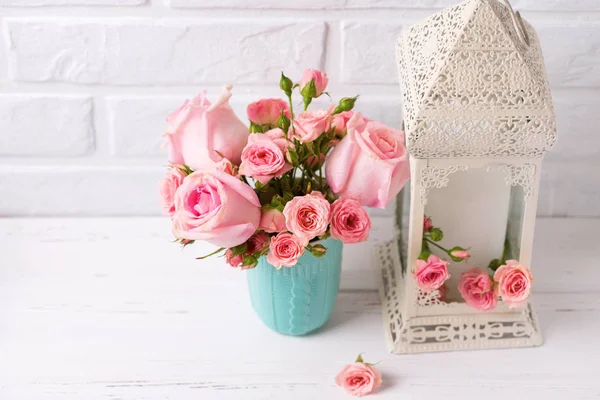 ピンクのバラの花ブルーのカップと白いレンガ壁に装飾的な白いランタン 花の静物画 選択と集中 テキストのための場所 — ストック写真