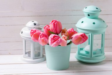 Nane taze pembe Lale çiçek renk kova ve ahşap arka plan üzerinde dekoratif fenerler. Çiçekli natürmort. Seçici odak. Metin için yer.
