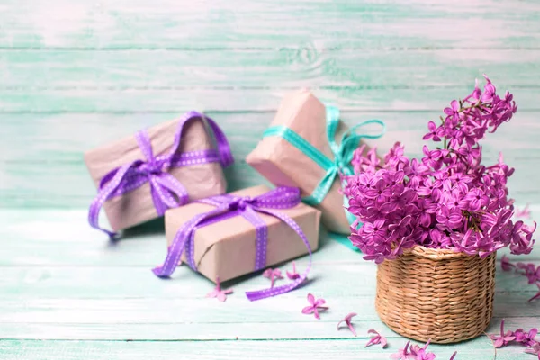 Aromatik Lila çiçek vazo ve turkuaz arka plan üzerinde hediye kutuları. Seçici odak. Metin için yer.