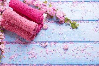 Pembe banyo havlusu mavi ahşap arka plan üzerinde kümesi