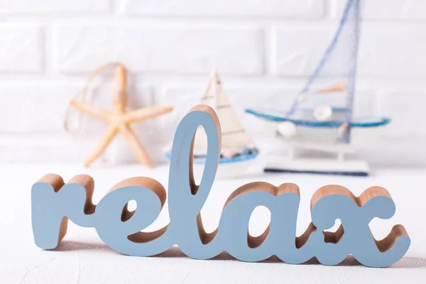Word relax and marine decorations on grey textured background