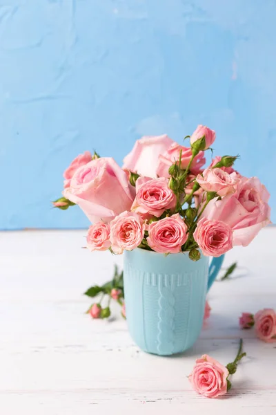 Rosa Rosor Blommor Blå Cup Mot Blå Texturerat Vägg — Stockfoto