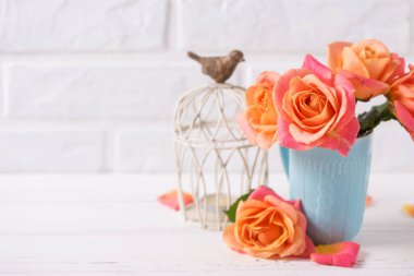 Taze turuncu gül ve beyaz arka plan üzerinde tuğla duvar üzerine de mum.