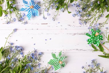 Mavi myosotis çiçek ve beyaz arka plan üzerinde dekoratif yel değirmenleri