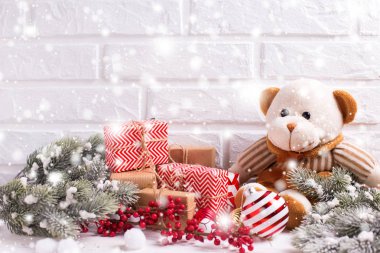 Beyaz arka plan üzerinde ayı oyuncak, Noel hediyeleri ve köknar ağacı dalları.
