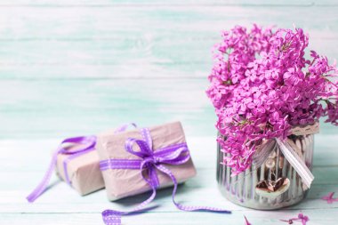 Mor çiçekler ve turkuaz arka plan üzerinde hediye kutuları.