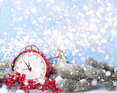 Mavi dokulu arka plan karşı saat ve çam dalları. 