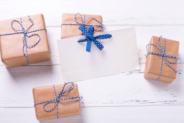 Boş etiket ve armağan üstünde Ahşap dokulu arka plan ile sarılmış hediye kutuları. Seçici odak etikettir. Metin için yer. 