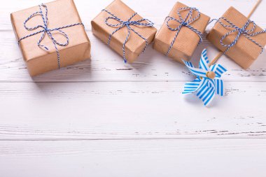 Festival hediye kutuları hediyeleri ve dekoratif mindmill dokulu Beyaz ahşap zemin üzerinde. Seçici odak. Metin için yer.