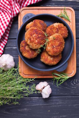 Ev yapımı pirzola otlar ve baharatlar siyah ahşap arka plan ile. Seçici odak. Dikey görüntü.