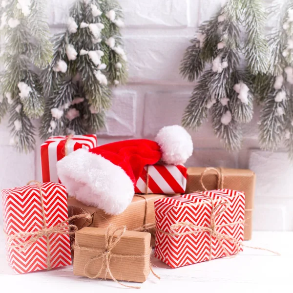 Winterfestdekoration Verpackte Weihnachtsgeschenke Dekorative Weihnachtsmütze Tannenzweige Auf Weißem Strukturiertem Hintergrund — Stockfoto