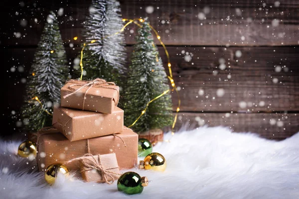 Empilement Cadeaux Enveloppés Sapins Décoratifs Boules Noël Contre Mur Bois — Photo