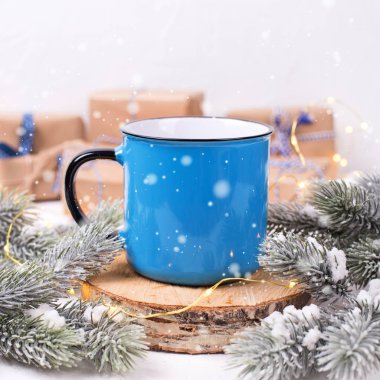 close up view of blue mug with winter decorations on white background
