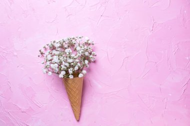 Pembe dokulu masa üzerinde beyaz gypsophila çiçek gözleme koni üstten görünüm