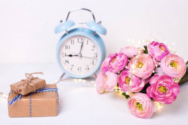 pembe tipik çiçekler ve beyaz zemin üzerine mavi çalar saat