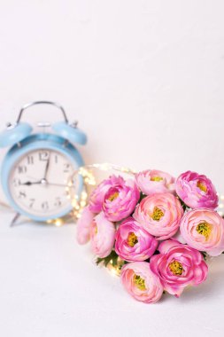 pembe tipik çiçekler ve beyaz zemin üzerine mavi çalar saat