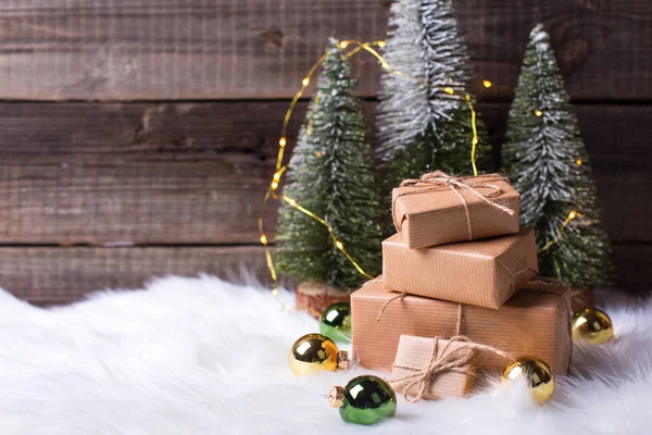 Empilement Cadeaux Enveloppés Sapins Décoratifs Boules Noël Contre Mur Bois — Photo