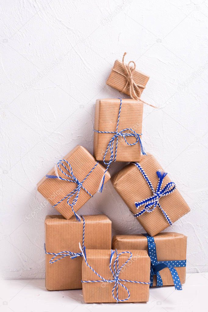 close up view of stack of wrapped christmas presents on white wall background