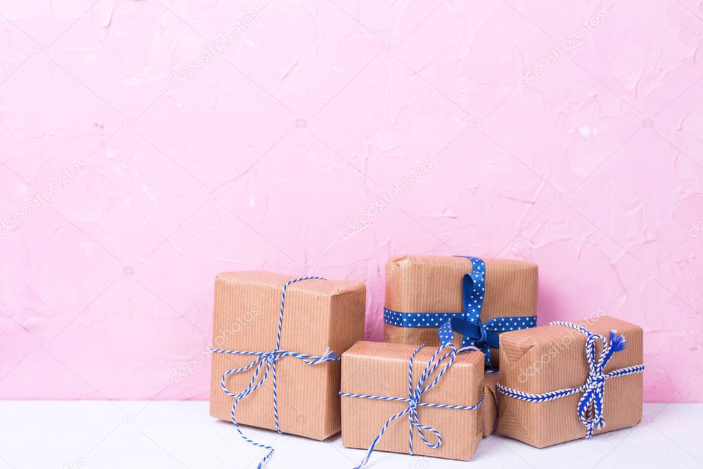 close up view of wrapped christmas presents on pink wall background