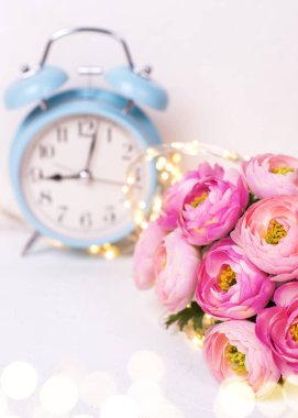 Pembe ranunculus çiçek ve mavi çalar saat o ile Arka plan