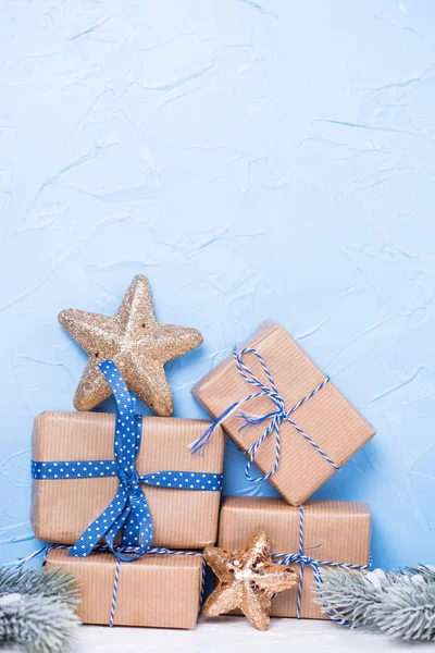 Stapel von verpackten Schachteln mit Geschenken, Tannenzweigen und gol — Stockfoto