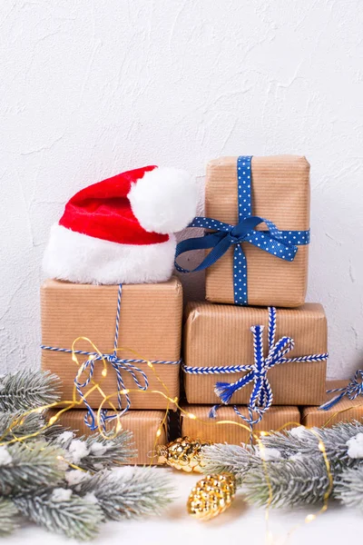 Pile de boîtes enveloppées avec cadeaux, chapeau de Père Noël rouge, sapin br — Photo