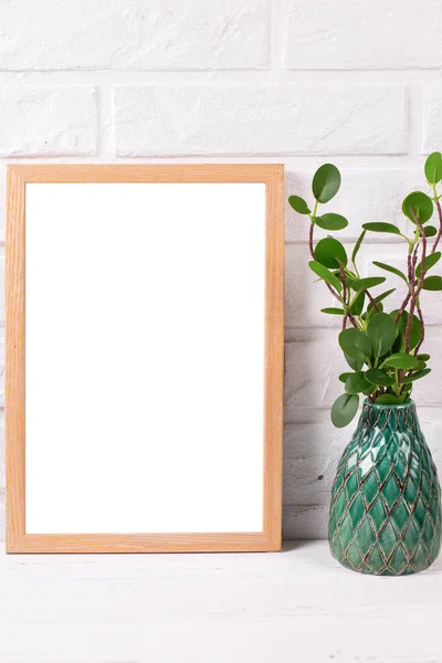 Пустая деревянная рамка макета с копировальным пространством и растением в зеленой ва — стоковое фото