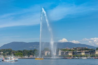 Jet d'eau, arka planda geneve kıyı şeridi ve mavi gökyüzü ile Cenevre şehir işareti. 500l su/s 140m ilâ 200 km/h Leman Gölü üzerinde yüksek jeti olduğunu / bu çeşme tarafından Cenevre Gölü.
