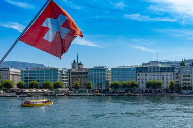İsviçre bayrağı önünde geneve manzarası, cathedrale saint-pierre geneve, tekne ve harika bir mavi gökyüzü pont du mont blanc köprü Cenevre ', İsviçre görüldüğü gibi sarı