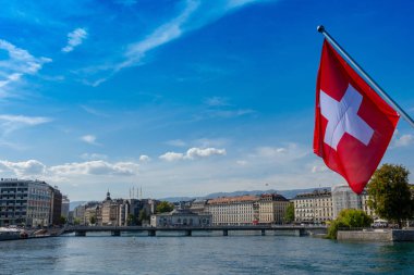 İsviçre bayrağı önünde geneve manzarası, cathedrale saint-pierre geneve, tekne ve harika bir mavi gökyüzü pont du mont blanc köprü Cenevre ', İsviçre görüldüğü gibi sarı