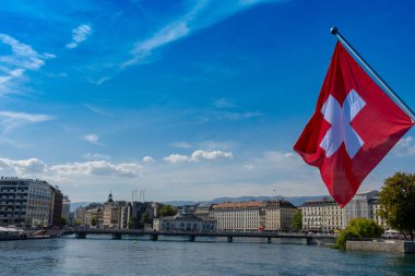 İsviçre bayrağı önünde geneve manzarası, cathedrale saint-pierre geneve, tekne ve harika bir mavi gökyüzü pont du mont blanc köprü Cenevre ', İsviçre görüldüğü gibi sarı