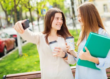 İki attracttive gülümseyen öğrenciler açık havada.