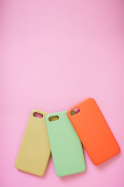 Pembe arka plan üzerinde akıllı telefon için renkli silikon kapakları seti.