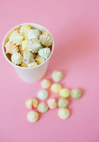 A cup of homemade mini meringues on pink background. — Stock Photo, Image