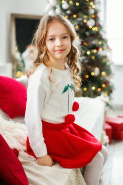 Noel ağacının yanındaki küçük kız.